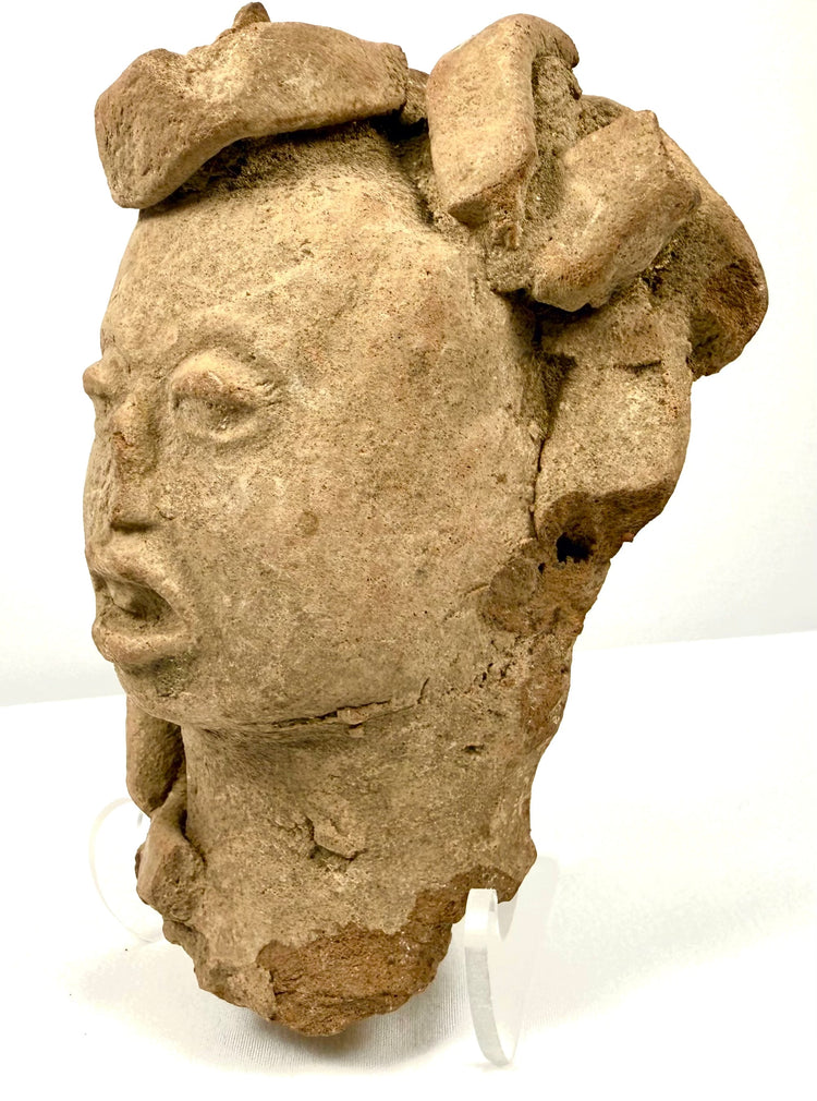 Three-quarter view of Mesoamerican terracotta head highlighting sculpted headdress depth