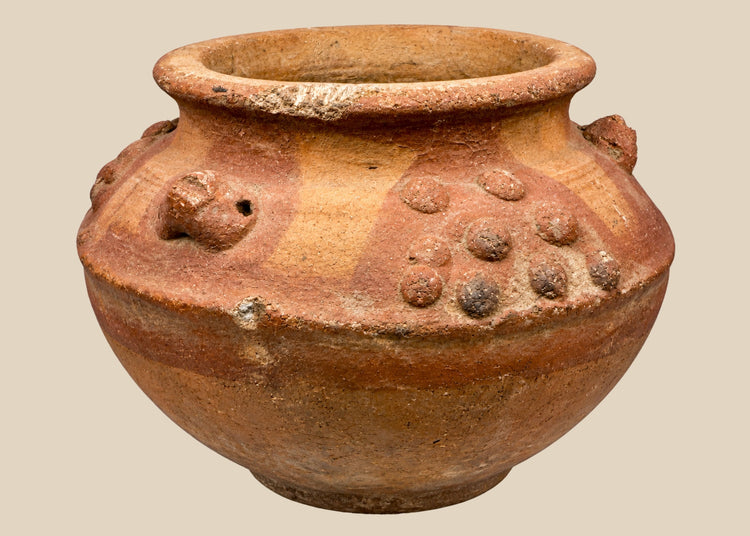 Pre-Columbian terracotta vessel from Central or South America, 800–1500 CE, featuring raised decorative clusters and sculpted motifs. Hand-molded clay vessel reflects Mesoamerican or Andean ritual and ceremonial craftsmanship, highlighting fertility and spiritual symbolism in ancient civilizations.
