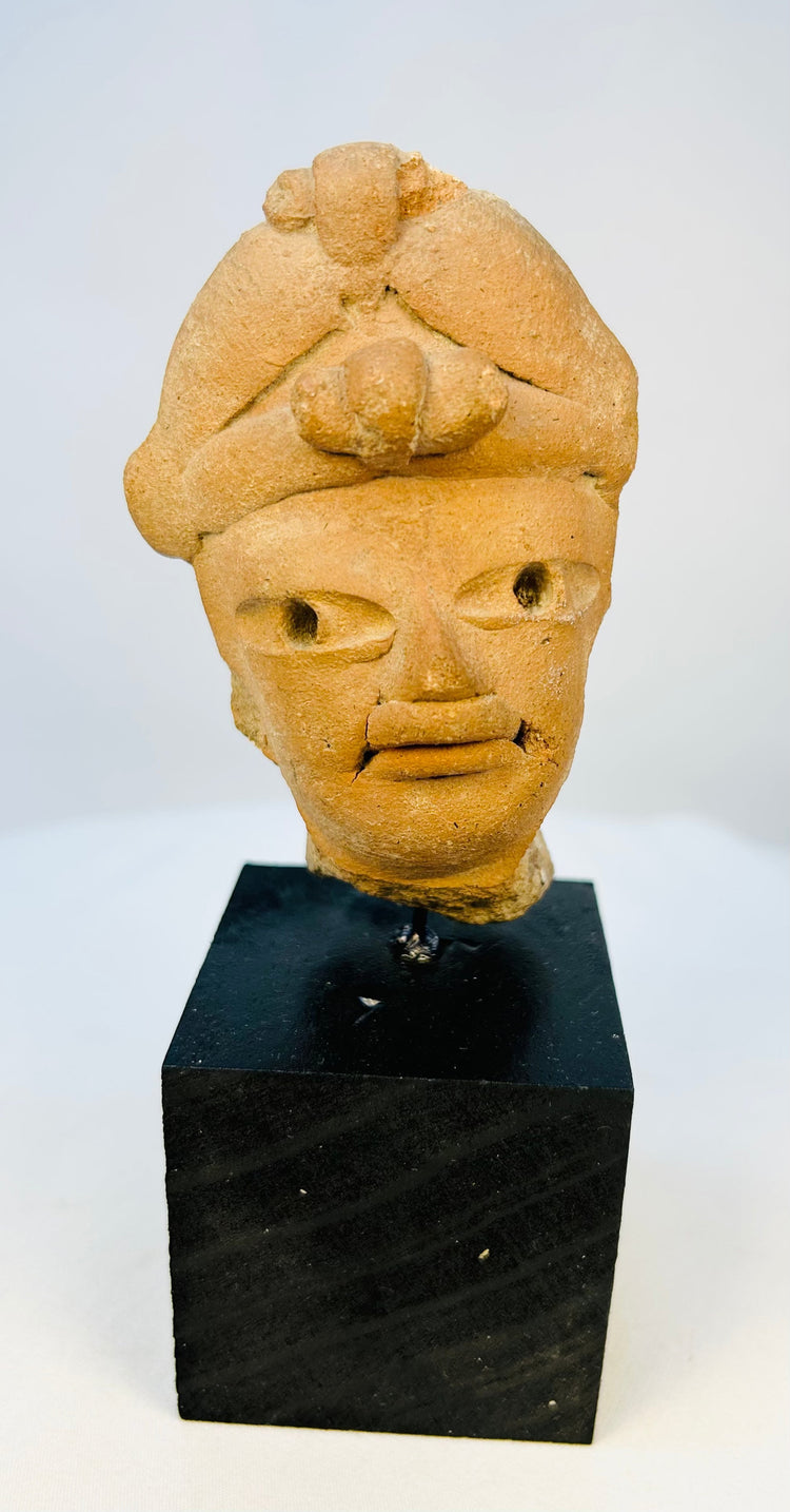 Close-up of Pre-Columbian terracotta ritual head showing facial details and headpiece