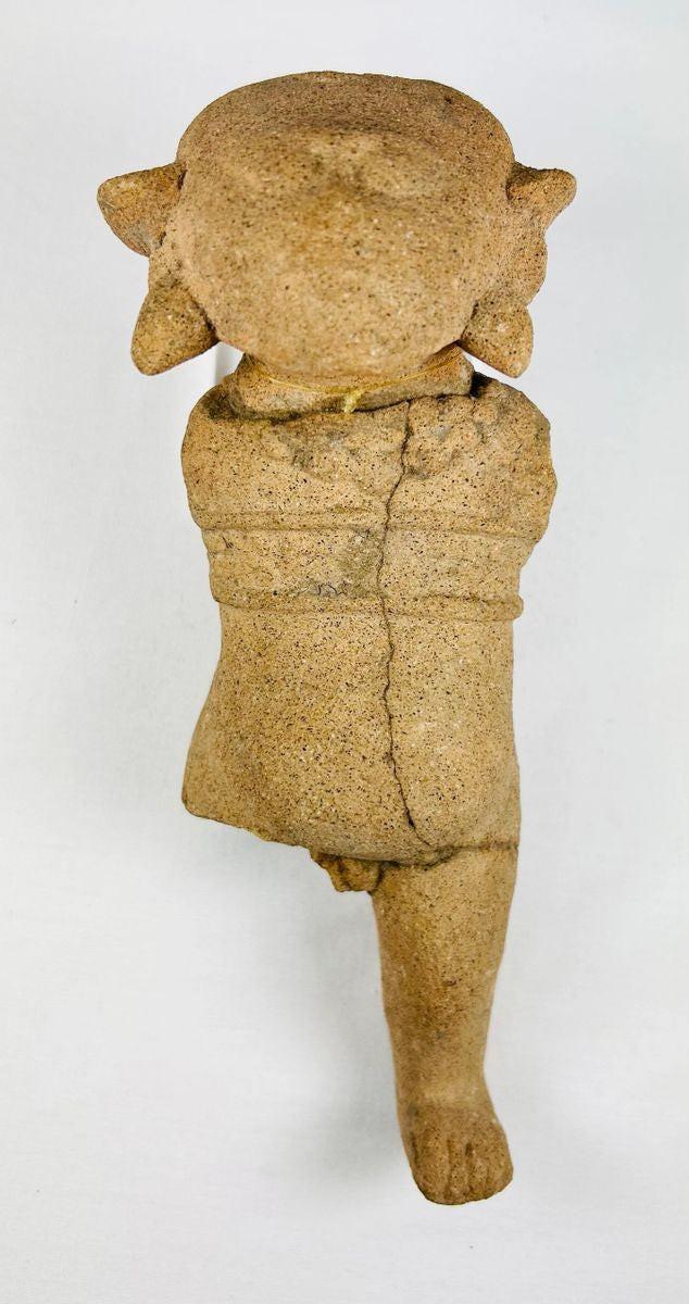 Ancient Pre-Columbian terracotta figurine with stylized facial features and unique headdress, likely Mayan or Zapotec, circa 500–1500 CE.
