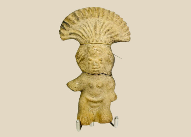 Ancient Pre-Columbian terracotta figurine depicting a standing figure with a wide fan-shaped headdress, stylized facial features, and rounded body, handmade from earthen clay, dating between 500–1500 CE, representing ceremonial or ritual iconography of Mesoamerican cultures.