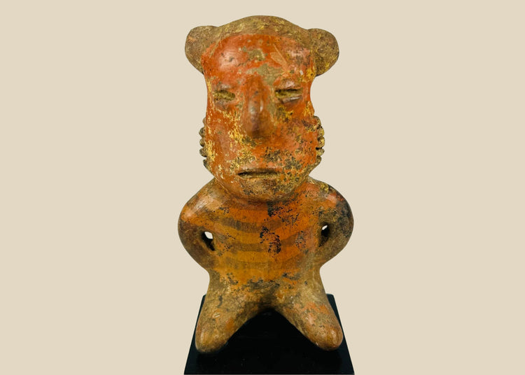 Pre-Columbian West Mexican terracotta figure, circa 300 BCE–500 CE, hand-modeled with stylized features and faint red-orange pigment, Nayarit, Colima, or Jalisco shaft tomb culture, mounted on display base