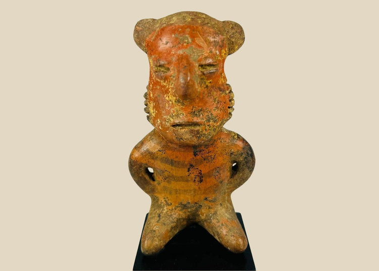Pre-Columbian West Mexican terracotta figure, circa 300 BCE–500 CE, hand-modeled with stylized features and faint red-orange pigment, Nayarit, Colima, or Jalisco shaft tomb culture, mounted on display base