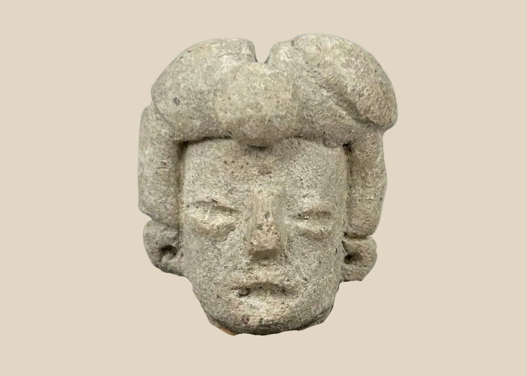 Ancient Pre-Columbian terracotta head fragment from West Mexico, Nayarit/Jalisco shaft-tomb culture, with almond-shaped eyes, straight nose, and stylized coiffure, mounted on a black display base, photographed on a white background.