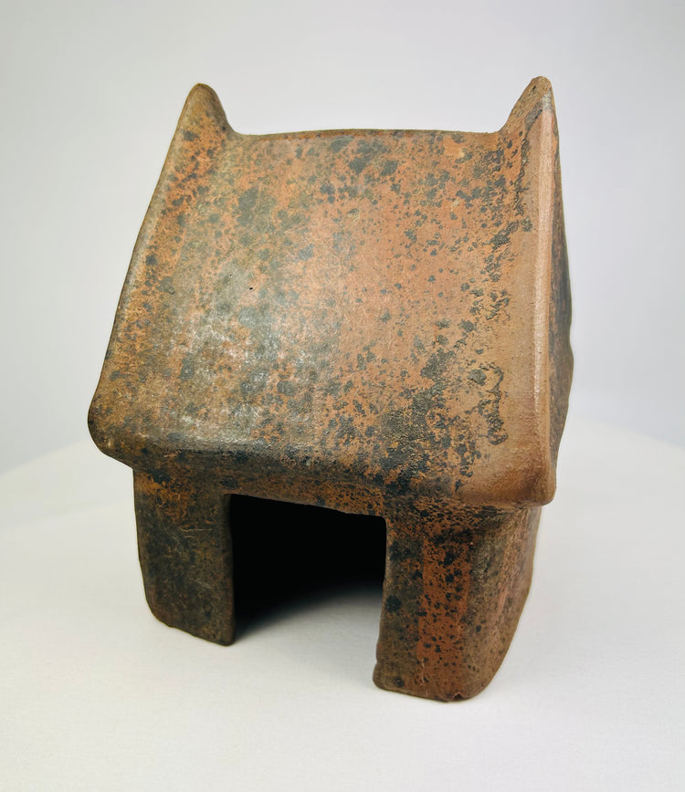 Pre-Columbian terracotta house model from West Mexico, front view on white background.