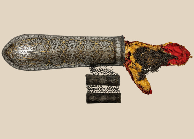 Persian Qajar-era steel bazu band (arm guard), 19th Century CE, featuring intricate gold koftgari inlay, original chain-mail lining, and rare red fabric interior. Designed for forearm protection in battle, combining functionality with luxurious artistry. Reflects Persian metalworking skill, military prestige, and elite craftsmanship of the Qajar dynasty.