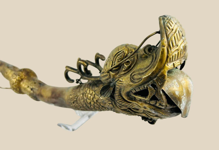 Ornate Qing Dynasty Tibetan ritual trumpet featuring an intricate bronze dragon head with detailed scales and open mouth, symbolizing power and protection, used in Buddhist ceremonial practices.