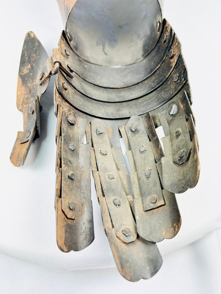 16th–17th-century style armoured gauntlet, forged steel construction, photographed on plain white.