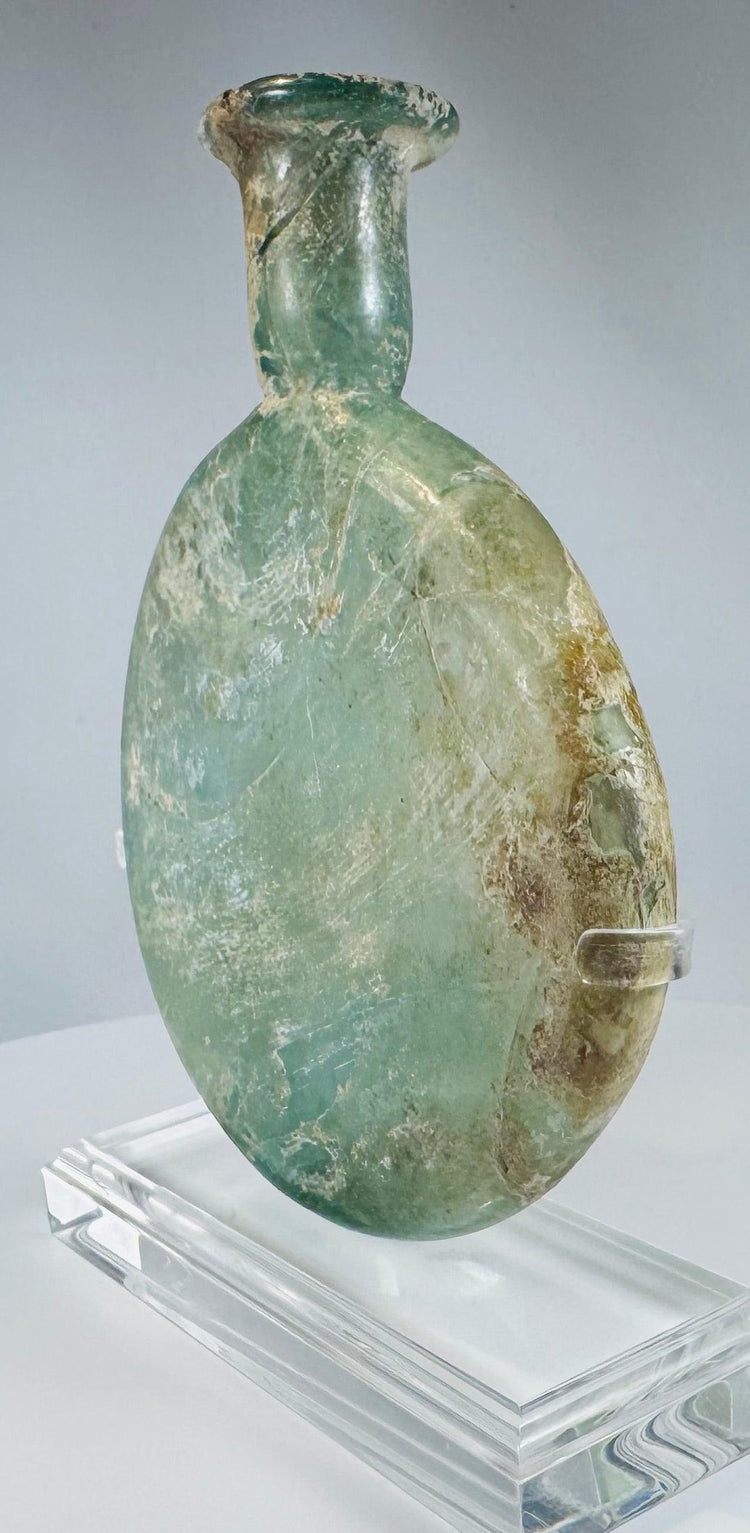 Roman Empire pale green glass vessel with burial weathering and elegant flattened profile