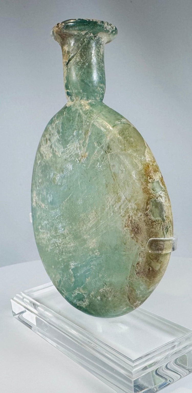 Roman Empire pale green glass vessel with burial weathering and elegant flattened profile