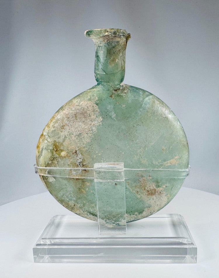 Roman archaeological glass flask showing iridescence, surface encrustation, and historic repairs
