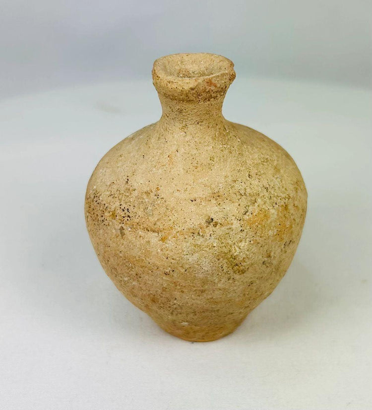 Roman terracotta juglet, 1st–3rd century CE, with rounded body, narrow neck, and flared rim, used for storing and pouring oils or perfumes, with natural aged patina.