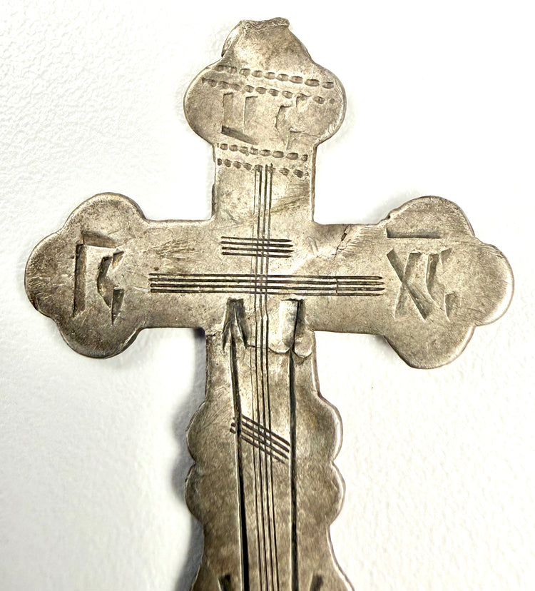 Close-up detail of engraved IC XC NC inscriptions on historic Russian Orthodox cross