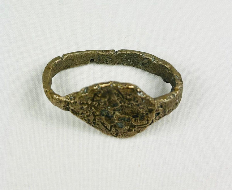 Ancient Sassanian bronze ring with engraved bezel depicting a lion and antelope predator-prey motif, symbolizing strength and balance, with rich green patina.