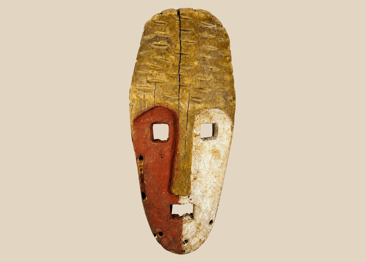 Papua New Guinea Sepik River tribal mask, hand-carved hardwood with red ochre and lime pigments, dual-colored face, circa 1900–1940.