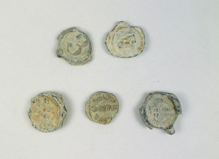 Marine-encrusted lead seals once used to identify bags and bales of traded goods