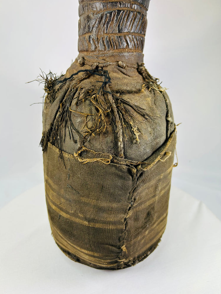 Wooden anthropomorphic figure from Central or West Africa with fiber torso wrapping and carved details