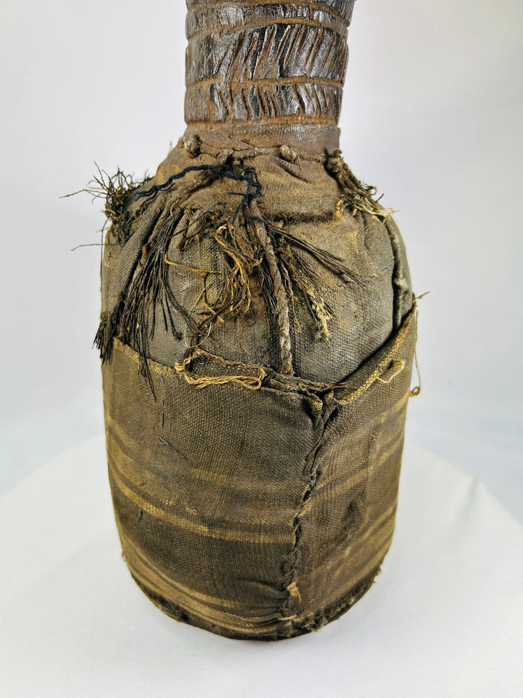 Wooden anthropomorphic figure from Central or West Africa with fiber torso wrapping and carved details