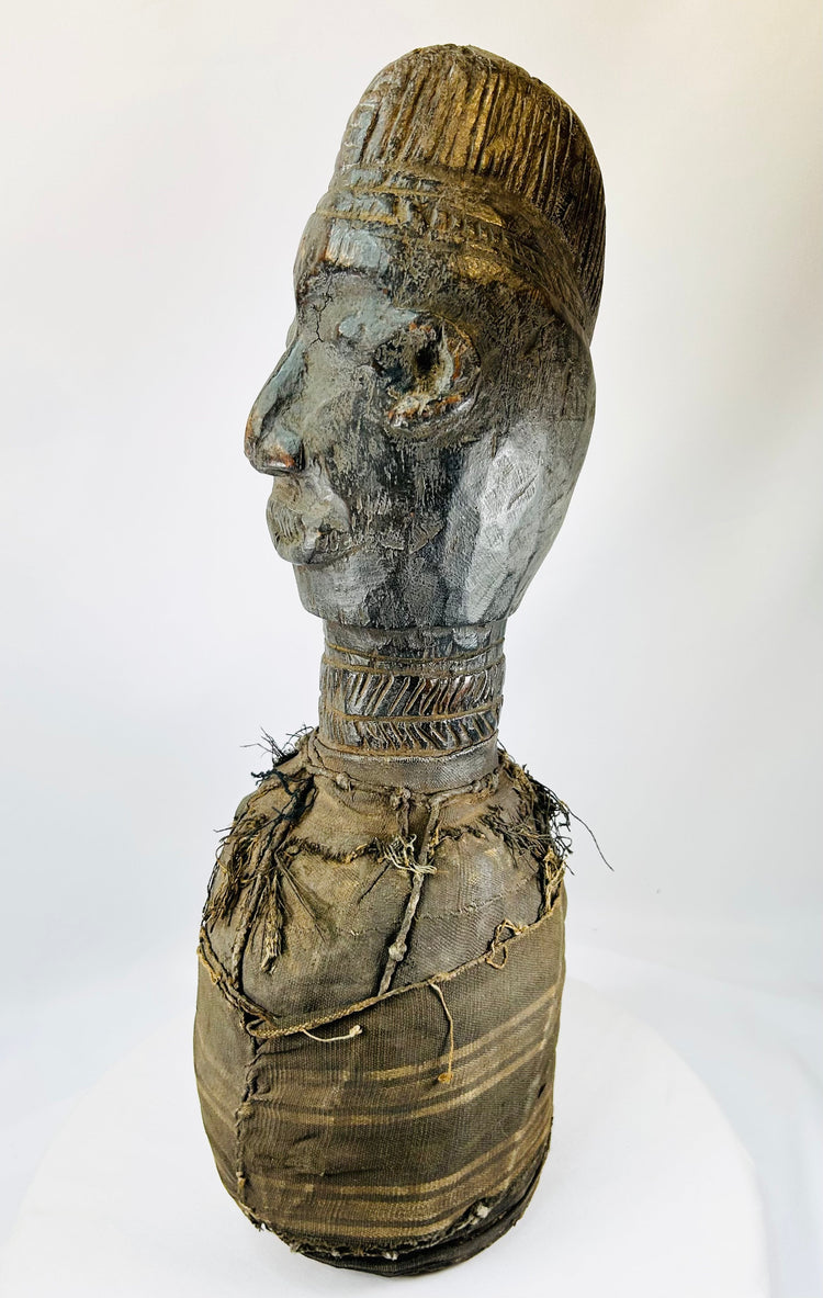 Traditional West African wooden figure, hand-carved with elongated features and organic pigment traces