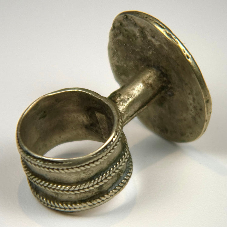 Late Victorian finger ring with raised rosette decoration and gently tapered silver-toned band