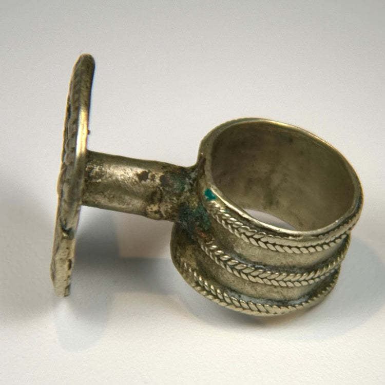 Late 1800s silver alloy ring displaying a raised rosette pattern and softly weathered surface