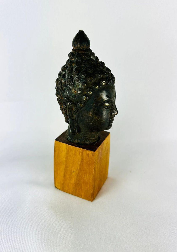 Antique Buddhist sculpture with closed eyes gentle smile and intricate hair curls