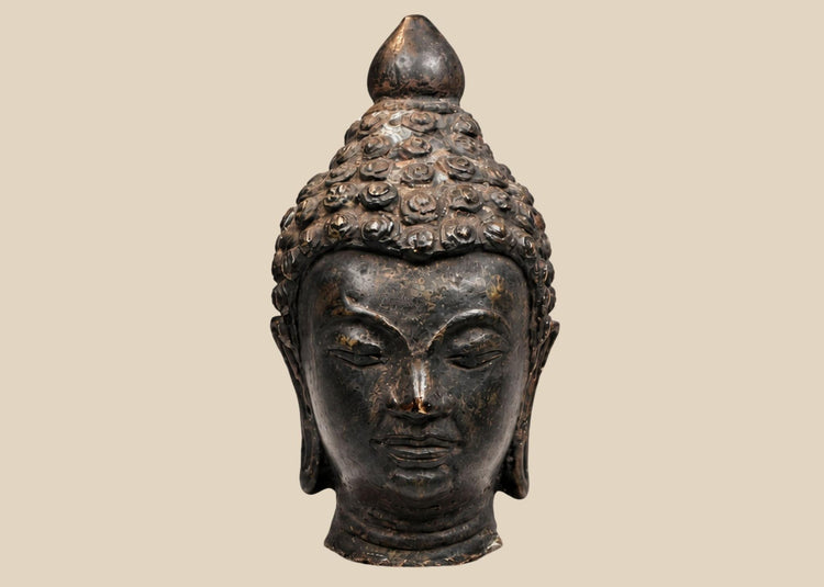 Southeast Asian bronze Buddha head sculpture with dark patina and serene expression