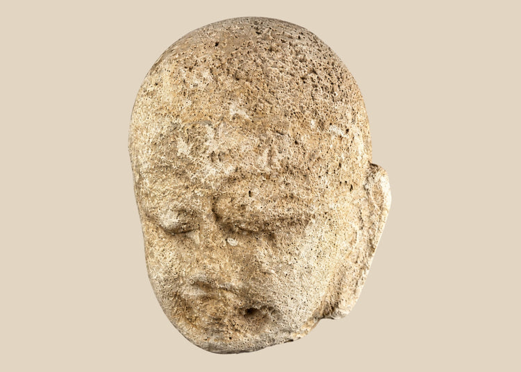 Southeast Asian carved stone Buddha head with serene expression and closed eyes, 13th–14th century, mounted on a modern black stand, Burma or Thailand.