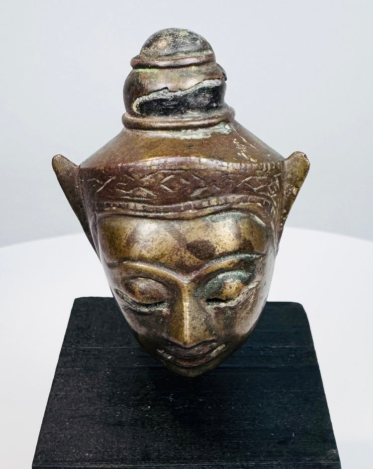 Antique Southeast Asian Buddha head sculpture with serene face, elongated ears, and decorative crown