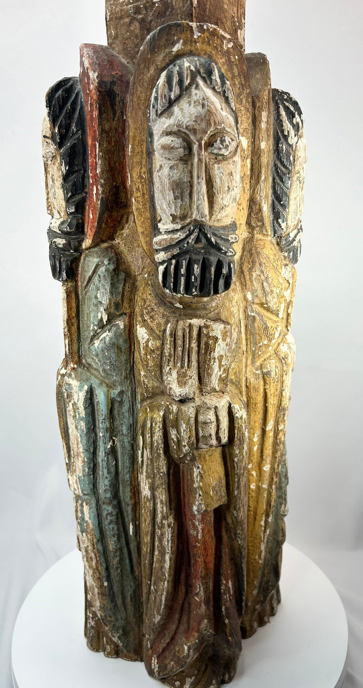 Historic Spanish Colonial church carving depicting four saints around a central column.