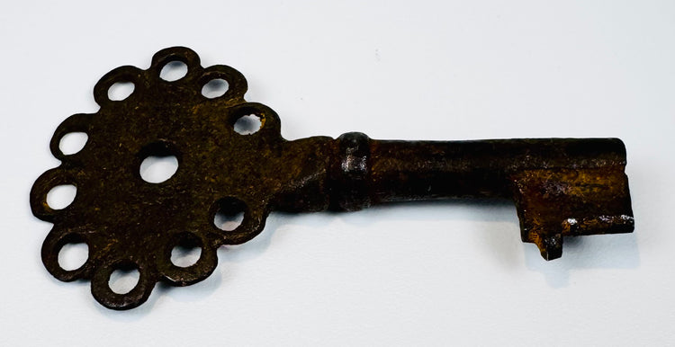Antique Spanish Empire key forged from iron, featuring a compact form, pierced bow, and aged patina.