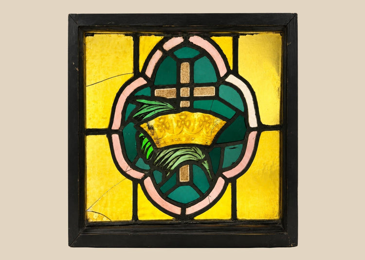 Vintage stained glass panel with cross and crown motif in amber, green, and pink glass