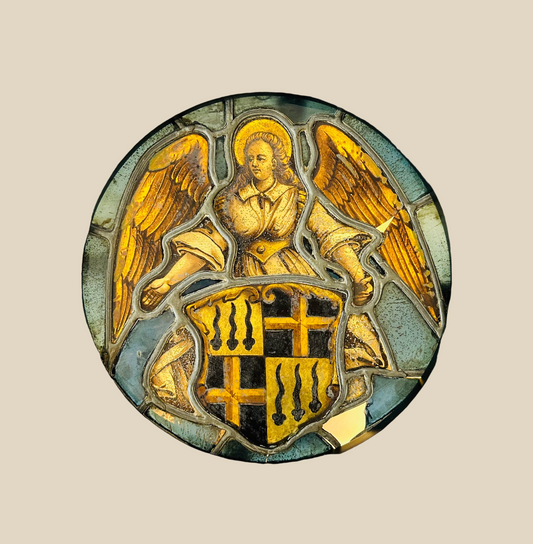 Circular 16th-century Swiss stained glass panel depicting a nimbate angel with outstretched wings holding a heraldic shield, featuring three ermine sables and golden crosses, deep blue background, Renaissance period, circa 1500–1550, professionally framed.