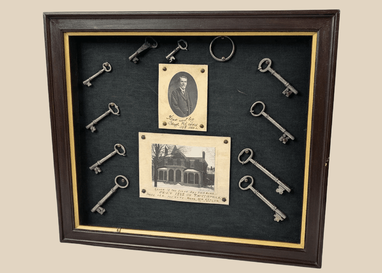 Framed 19th-century display with eleven iron keys, portrait of night watchman Hugh Newell, and early photograph of T. McCormick’s 1867 factory, preserved in a wooden shadowbox.