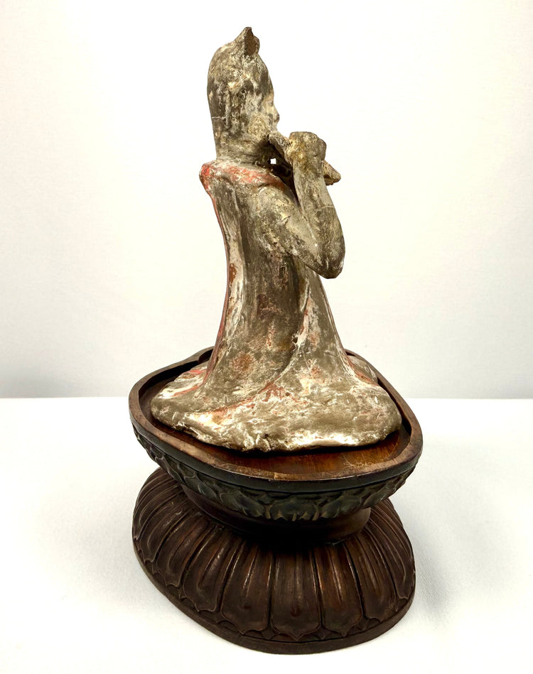 Ancient Chinese female court musician holding a pan flute, mounted on a later-added carved wooden display stand.