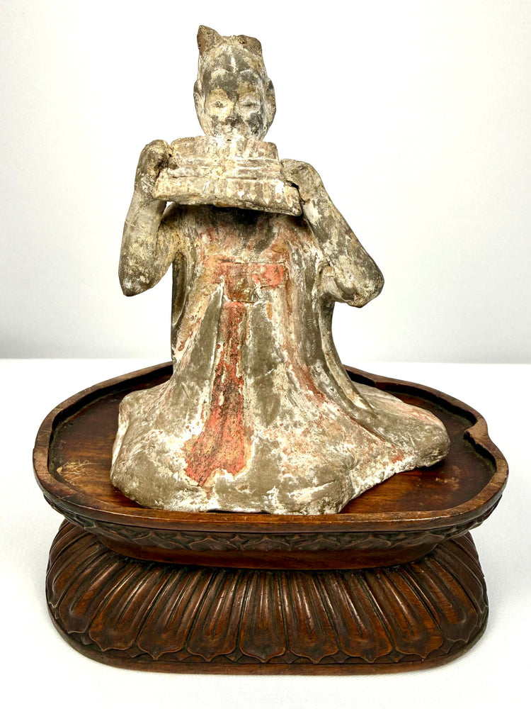 Ancient Chinese Tang Dynasty terracotta seated female musician playing a traditional pan flute, circa 618–907 CE.