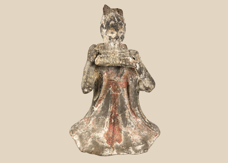 Tang Dynasty terracotta figure of a seated female court musician playing a pan flute, traces of red and white pigments, displayed on a carved wooden stand, 7th–9th century China.