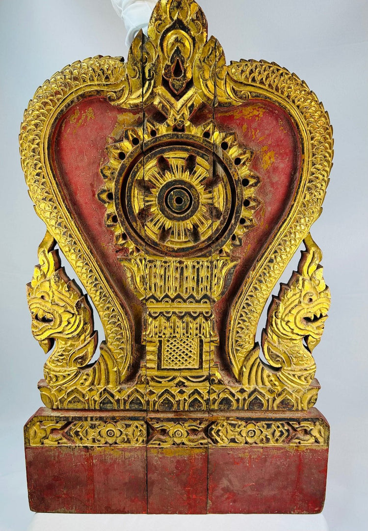 Close-up of high-relief gold leaf carving on Thai Buddhist shrine panel