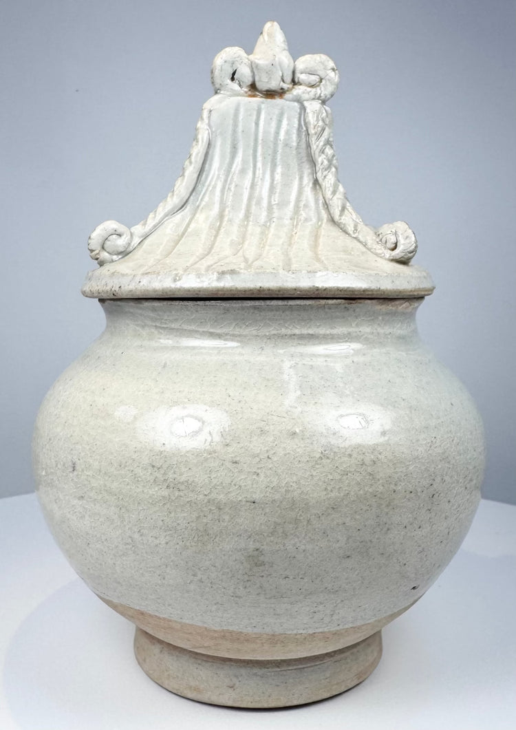 Early Thai covered stoneware jar attributed to Sawankhalok kilns with ornate fitted lid and aged glaze crazing.