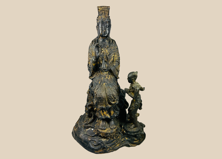 Front view of Thai cast bronze Guanyin with child attendant seated on lotus pedestal, showing traces of original gold gilding.