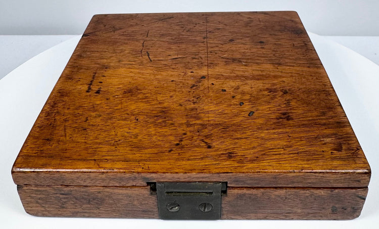 Closed walnut case of a mid-19th-century Thomas Jones surveying compass showing its figured wood grain and aged surface patina.