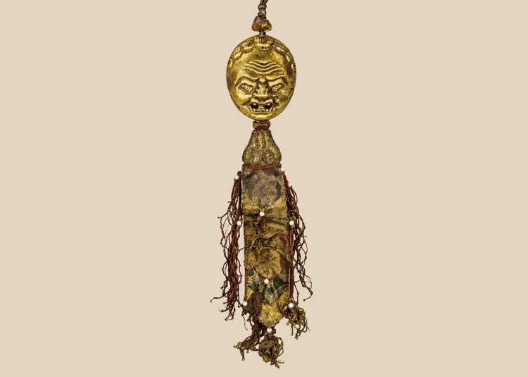 Tibetan gilt bronze guardian mask pendant with silk tassels and beads