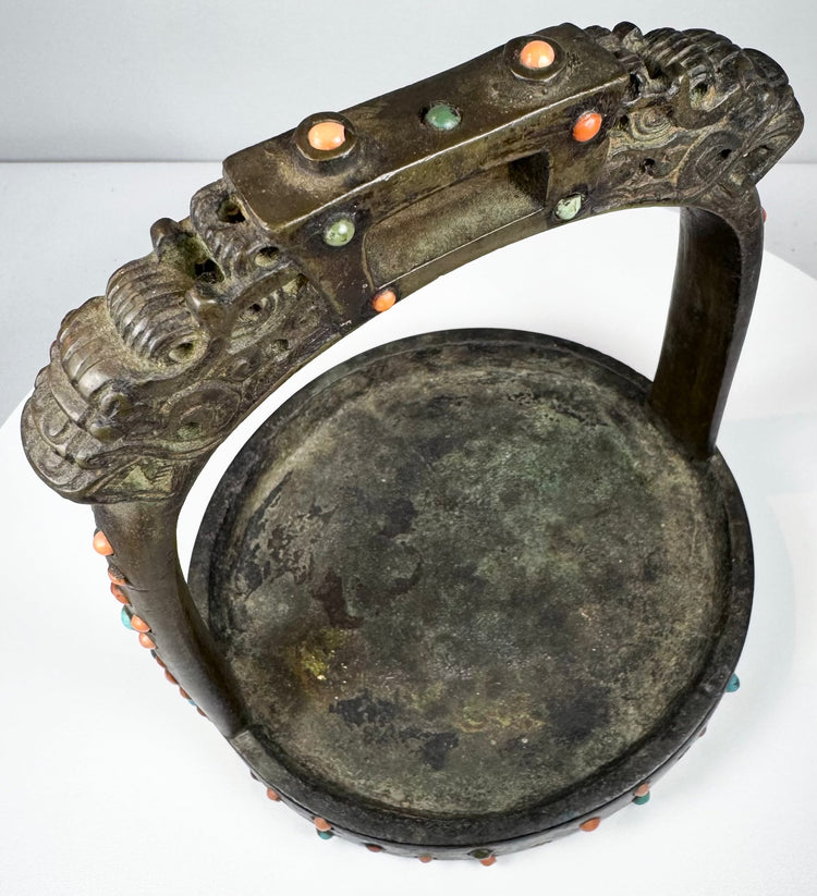 Late Qing period ceremonial stirrup decorated with coral, turquoise, and glass cabochons set into cast bronze.