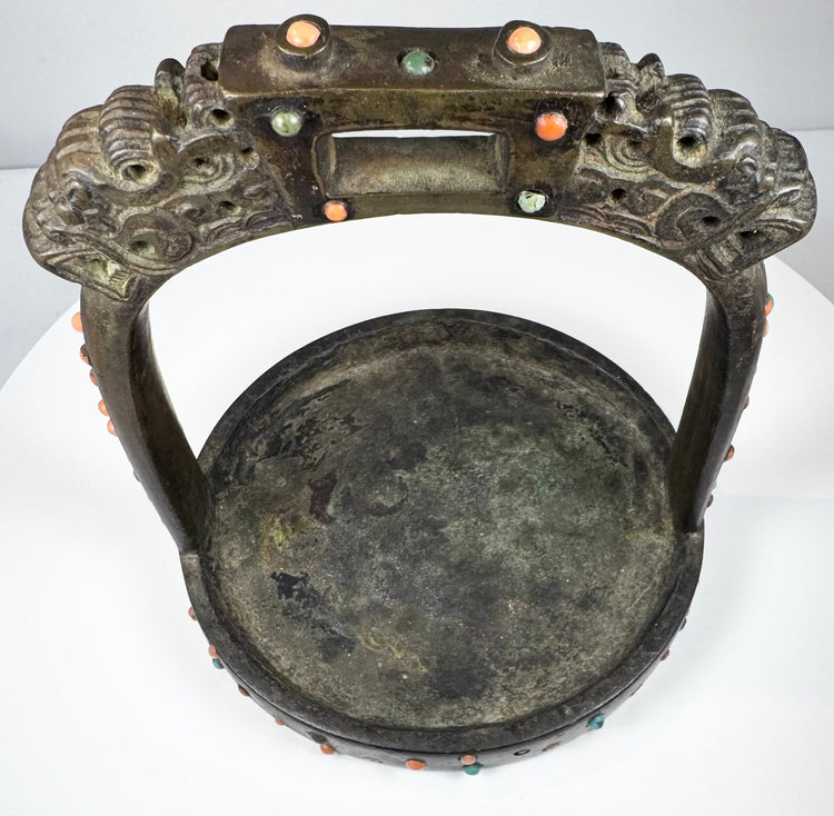 Mongolian or Tibetan equestrian stirrup featuring dragon-head finials, wide tread, and elaborate jeweled decoration.