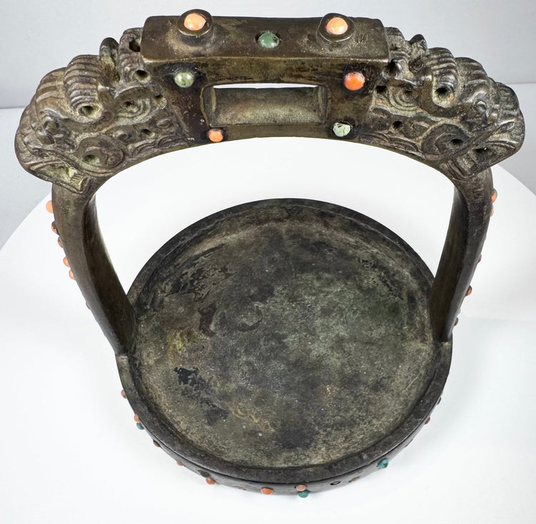 Mongolian or Tibetan equestrian stirrup featuring dragon-head finials, wide tread, and elaborate jeweled decoration.