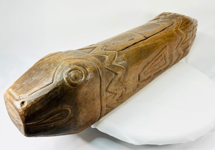 Close-up of antique wooden fish drum highlighting carved eye and mouth details with visible patina.
