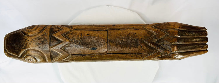 Overhead view of the tribal fish drum showing symmetrical carved body and aged patina.