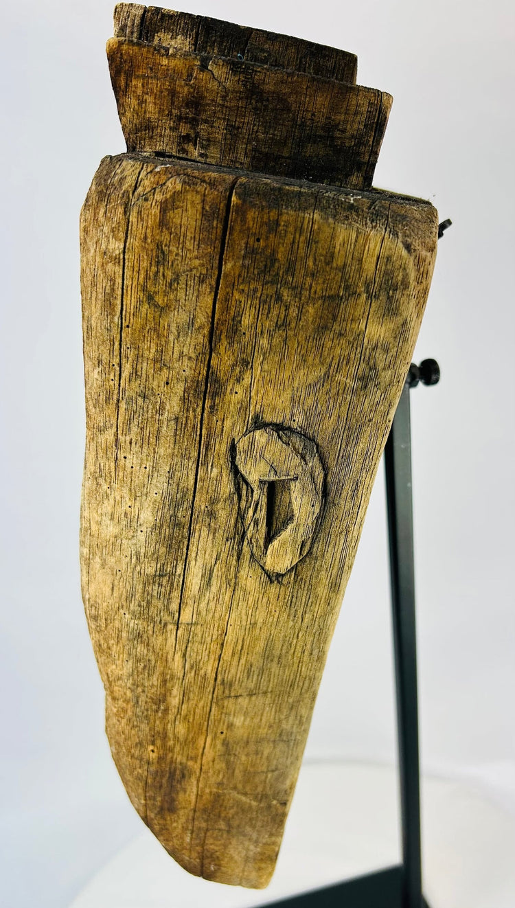 Profile view of ethnographic ritual mask emphasizing wood grain, aged texture, and ceremonial wear.