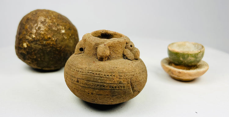 Medieval period miniature jar and green-glazed ritual cup alongside polished stone sphere, Asian archaeological artifacts.