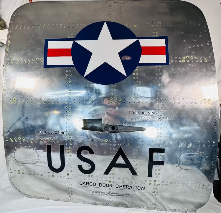 Front detail of the Boeing cargo door showing the USAF Star and Bars insignia and reflective aluminum surface